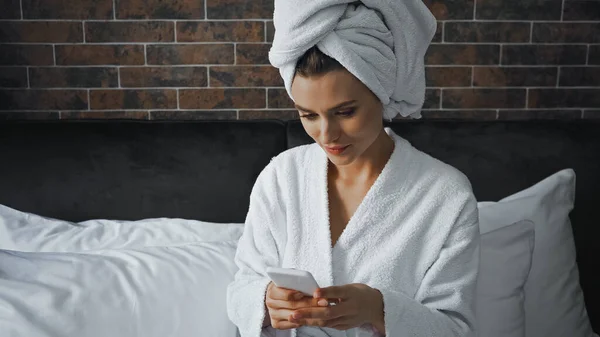 Mujer Toalla Blanca Mirando Teléfono Inteligente Durante Mensajería Habitación Hotel — Foto de Stock