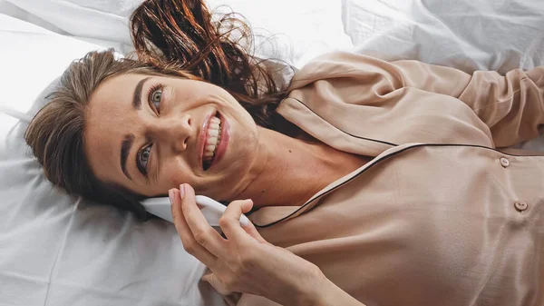 Pandangan Atas Wanita Ceria Berbicara Smartphone Saat Berbaring Tempat Tidur — Stok Foto