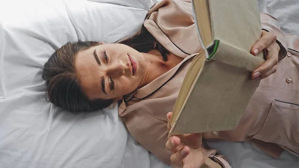 Pandangan Atas Wanita Membaca Novel Saat Berbaring Tempat Tidur — Stok Foto