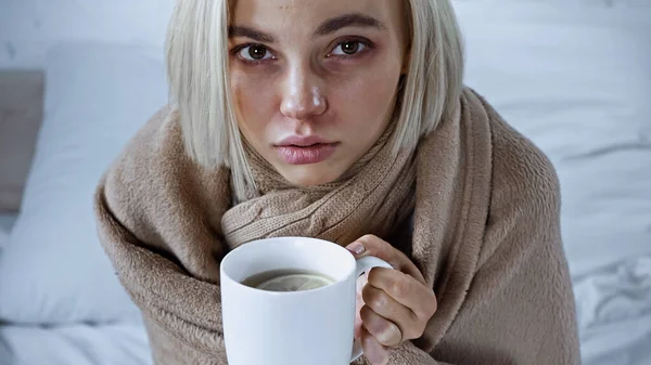 Sick Woman Wrapped Blanket Holding Cup Warm Tea Bedroom — Zdjęcie stockowe