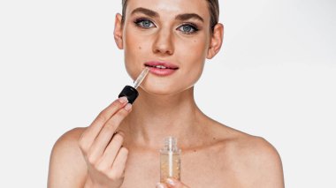 woman with naked shoulders applying serum with pipette isolated on white clipart