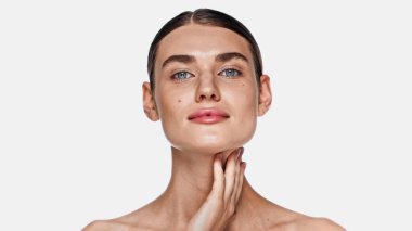 Mükemmel ve temiz tenli esmer kadın beyaz kameraya bakıyor.