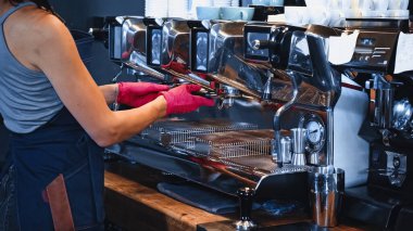 partial view of barista holding portafilter in coffee shop clipart