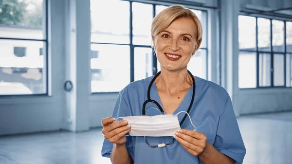 Smiling Mature Doctor Holding Medical Mask Clinic — Stock Photo, Image