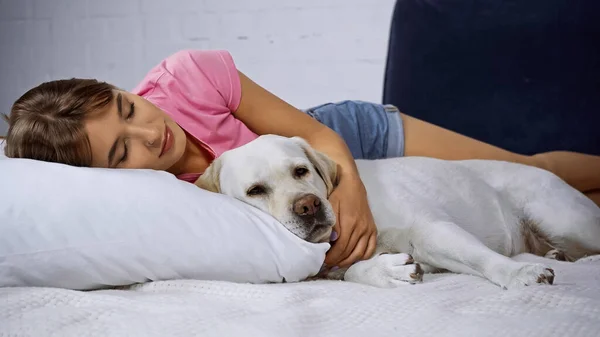 Jonge Vrouw Met Gesloten Ogen Liggend Met Gouden Retriever Bed — Stockfoto
