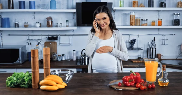 Smiling Pregnant Woman Talking Smartphone Fresh Vegetables Orange Juice Kitchen — Stock Photo, Image