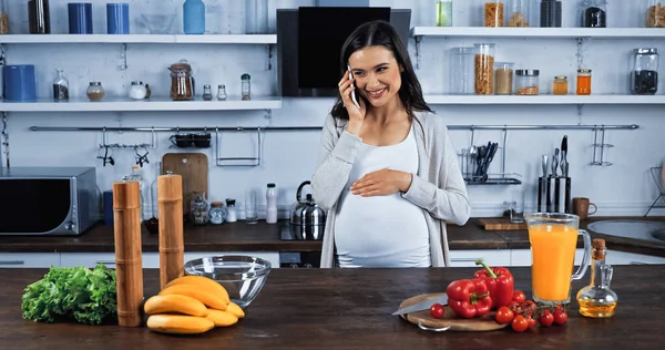 Mulher Grávida Sorridente Falando Smartphone Perto Legumes Frescos Suco Laranja — Fotografia de Stock