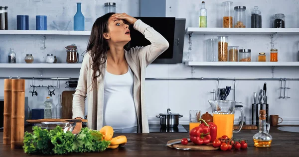 Mujer Embarazada Asombrada Pie Cerca Alimentos Frescos Jugo Naranja Mesa — Foto de Stock