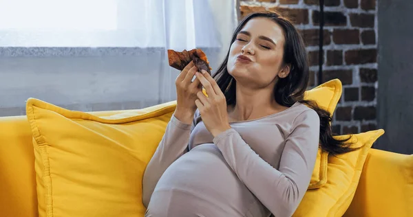 Радостная Беременная Женщина Ест Вкусный Кекс Дома — стоковое фото