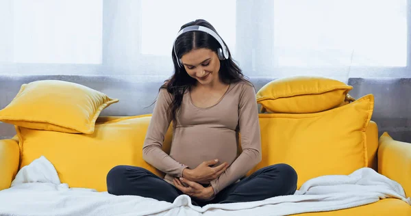 Sorrindo Mulher Grávida Fones Ouvido Abraçando Barriga Sala Estar — Fotografia de Stock