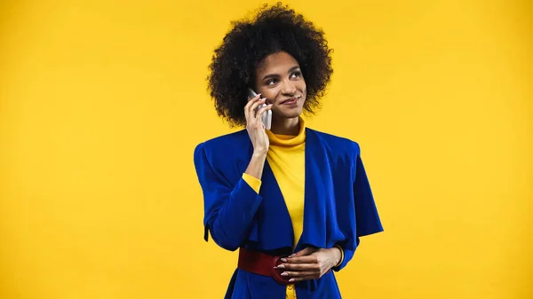 Leende Afrikansk Amerikansk Kvinna Blå Jacka Talar Smartphone Isolerad Gul — Stockfoto