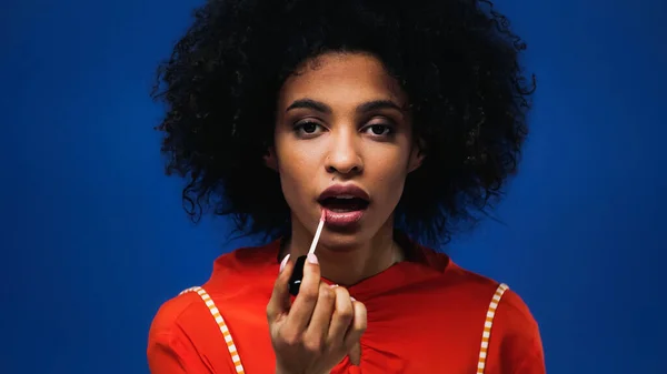 Afroamerikanerin Trägt Lipgloss Isoliert Auf Blau Auf — Stockfoto