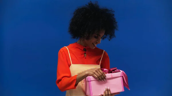 Sorrindo Afro Americana Segurando Presente Isolado Azul — Fotografia de Stock