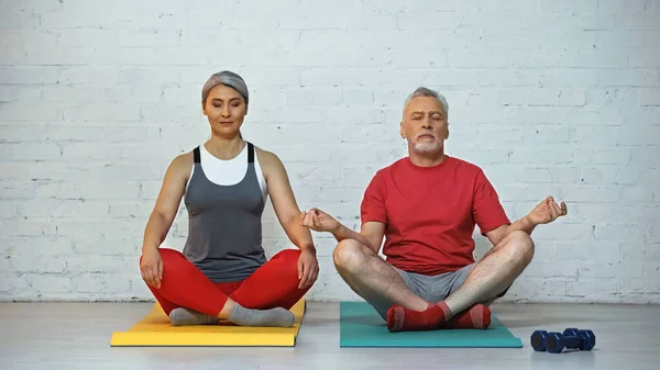 Ältere Interrassische Paare Meditieren Lotus Pose Auf Fitnessmatten — Stockfoto