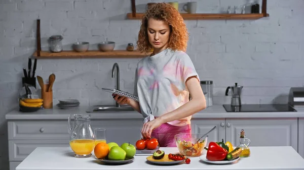 Mulher Encaracolado Segurando Notebook Segurando Pesando Tomates Perto Legumes Suco — Fotografia de Stock