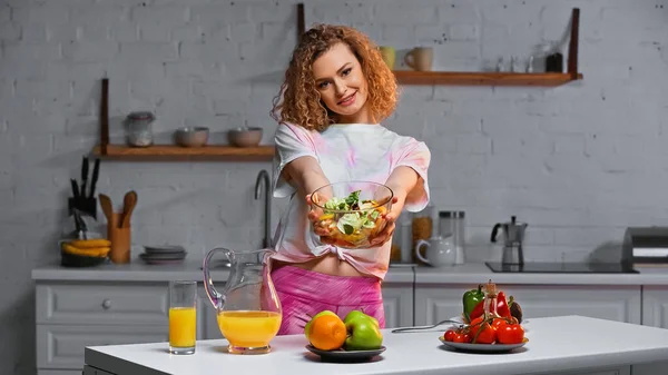 Smiling Curly Woman Holding Bowl Salad Kitchen — Stock Photo, Image