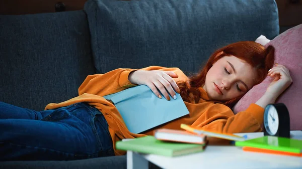 Red Haired Girl Sleeping Book Alarm Clock Blurred Foreground — Stock Photo, Image