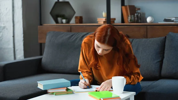 Studentin Schreibt Auf Notizbuch Neben Tasse Hause — Stockfoto