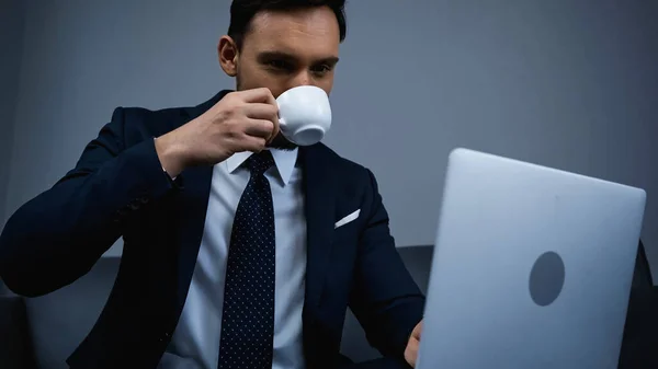 Manager Drinking Coffee Laptop Blurred Foreground Hotel Room — Stock Photo, Image