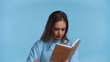 Yumuşak kazaklı, kitap okuyan, maviden izole genç bir kız.