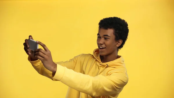 Glad Afrikansk Amerikansk Tonåring Pojke Luvtröja Tar Selfie Isolerad Gul — Stockfoto