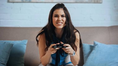 KYIV, UKRAINE - Mart 04, 2021: video oyunu oynayan endişeli genç kadın 