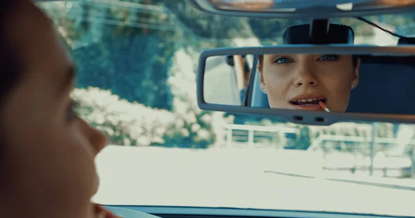 Blurred Happy Woman Applying Lip Gloss While Looking Rearview Mirror — Stock Photo, Image