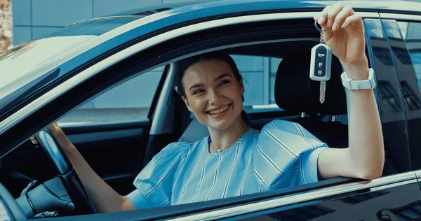 新しい車から鍵を握る陽気な若い女性 — ストック写真