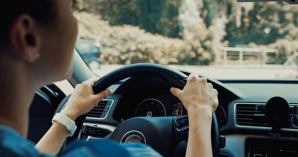 young woman holding steering wheel while driving car