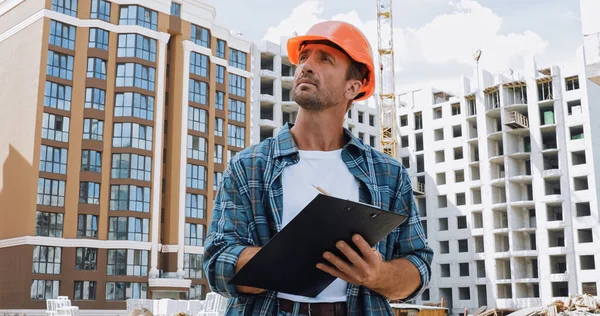 Builder Hard Hat Holding Clipboard Construction Site — Stock Photo, Image