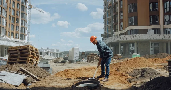建設現場でシャベルで地面を掘るハード帽子の中年の建築家 — ストック写真