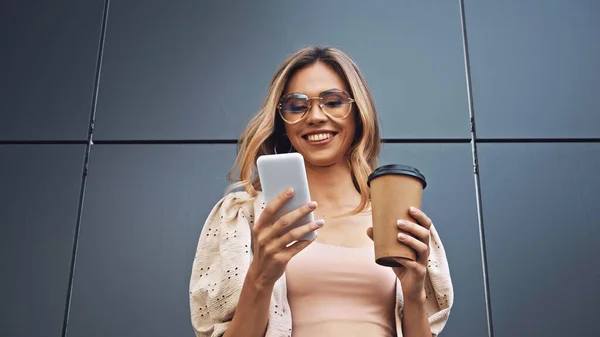 Happy Woman Holding Coffee Using Smartphone Building — Stock Photo, Image
