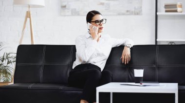 Zarif bir iş kadını cep telefonuyla konuşuyor.