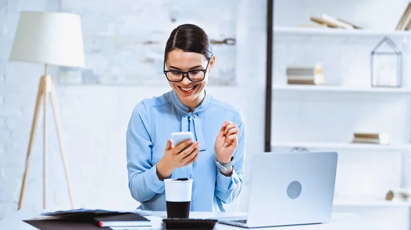 Mulher Negócios Alegre Usando Smartphone Perto Café Para Laptop Local — Fotografia de Stock