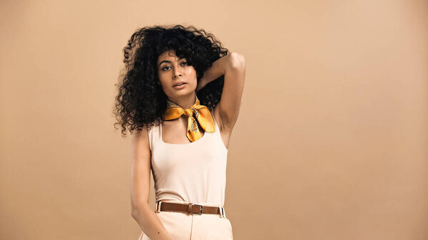 Молодая латиноамериканка позирует изолированно на бежевом 