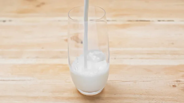 Leche Fresca Vertiendo Vaso Sobre Una Mesa Madera —  Fotos de Stock