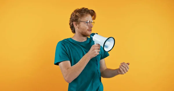 stock image redhead man in glasses holding megaphone isolated on yellow