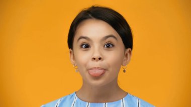 preteen child sticking out tongue isolated on yellow clipart