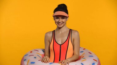 smiling young woman in swimsuit and inflatable ring isolated on yellow clipart