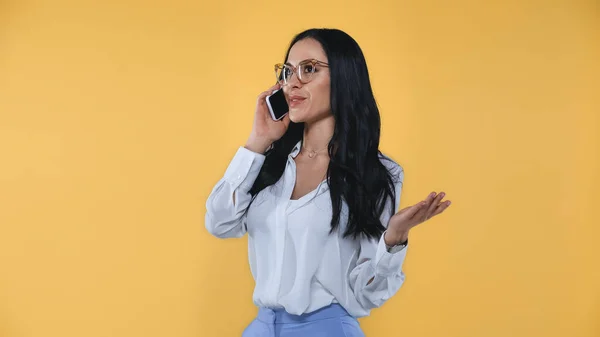 Gülümseyen Kadını Cep Telefonuyla Konuşurken Sarıda Izole Bir Şekilde Işaret — Stok fotoğraf