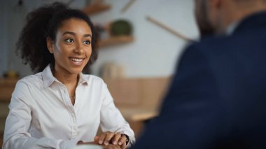 Kafedeki bulanık adama bakan Afro-Amerikan kadın