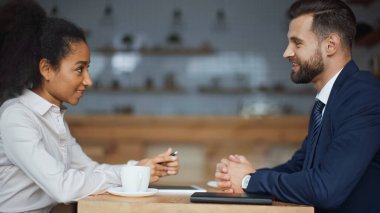 Kafe 'deki sabah toplantısında mutlu ırklar arası iş ortaklarının yan görüşü
