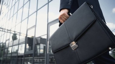 cropped view of businessman holding leather briefcase  clipart