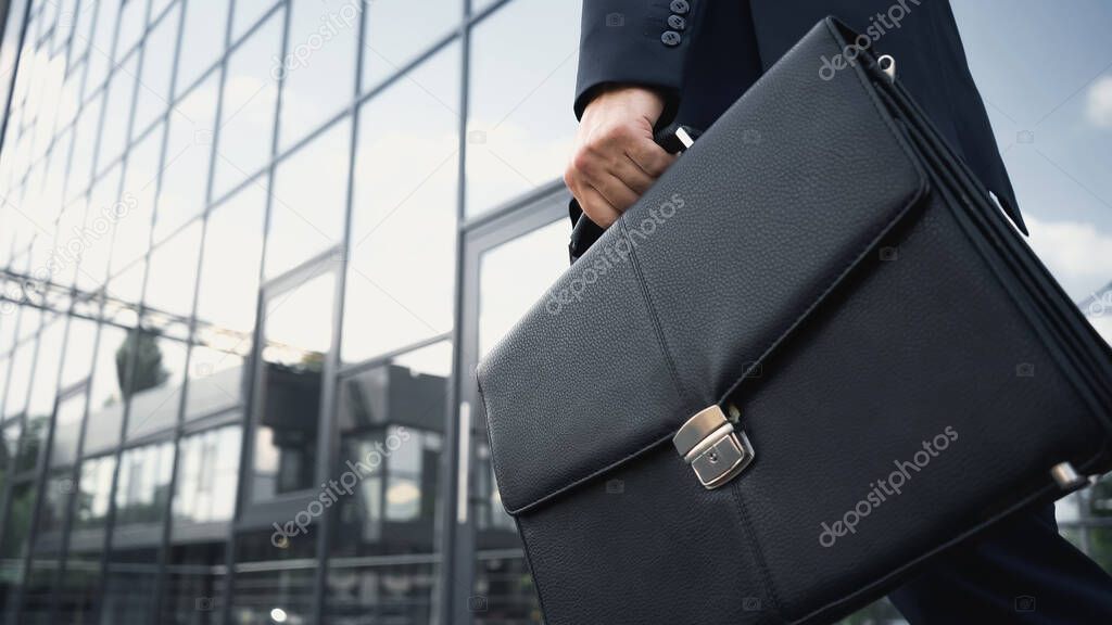 cropped view of businessman holding leather briefcase 