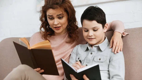 Mutter Und Sohn Bei Hausaufgaben Mit Buch Und Notizbuch Hause — Stockfoto
