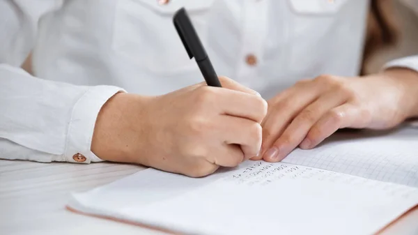 Vista Ritagliata Del Bambino Che Scrive Sul Taccuino Durante Compiti — Foto Stock