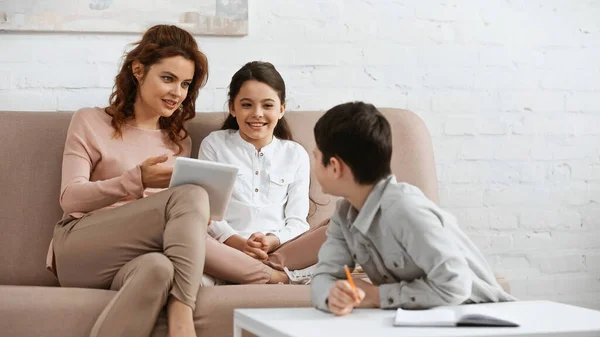 Smiling Woman Holding Digital Tablet Daughter Son Doing Homework Blurred — Stock Photo, Image