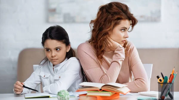 Unzufriedene Frau Schaut Bei Tochter Weg Und Bücher Verschwommenen Vordergrund — Stockfoto