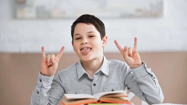 Preteen Boy Showing Rock Gesture Sticking Out Tongue Books Blurred — Stock Photo, Image