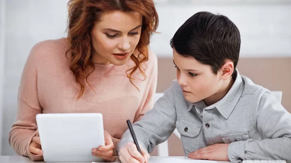 Madre Sosteniendo Tableta Digital Cerca Hijo Con Pluma Durante Educación — Foto de Stock